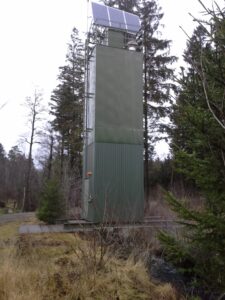 Bilden visar en solcells- och vindkraftsdriven kalkdoserare över Århultbäcken på Hallandsås.